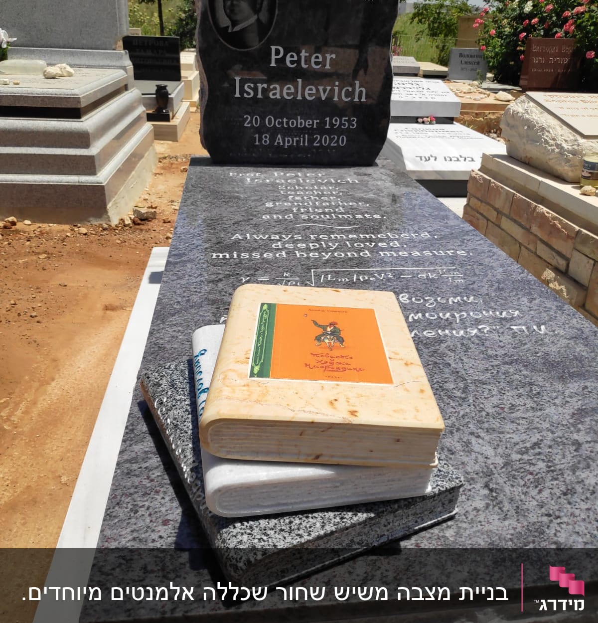 מצבה שחורה עם כיתוב ותמונה, ספרים מונחים עליה